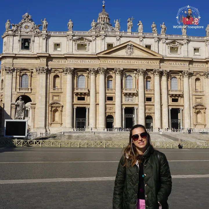 The author in front of the façade of St Peter's Basilica, with the statue of St Peter on the left and the square empty