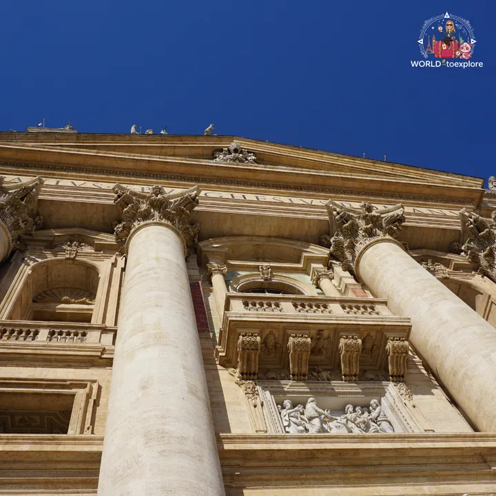 The basilica façade seen from below, with the travertine columns, the Corinthian capitals and a carved relief