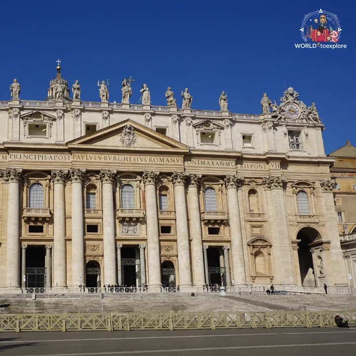The façade of St Peter's Basilica seen head-on, with the statues on top and the clock, and nobody in the square