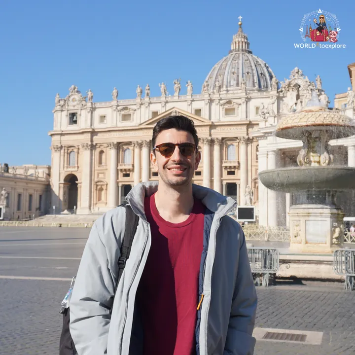 The author's partner in front of the basilica, with the dome and one of the square's fountains behind him