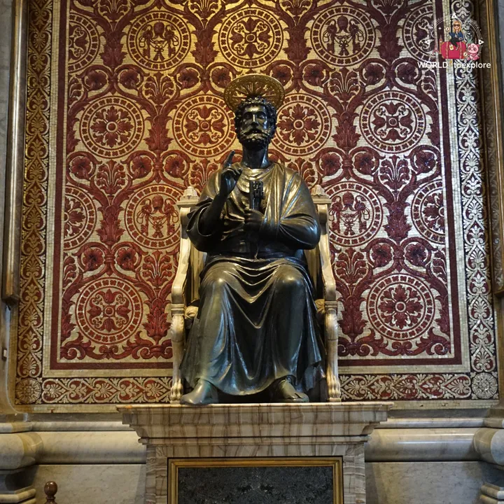 The bronze statue of St Peter seated on his throne, holding the key, against a background of red and gold mosaics