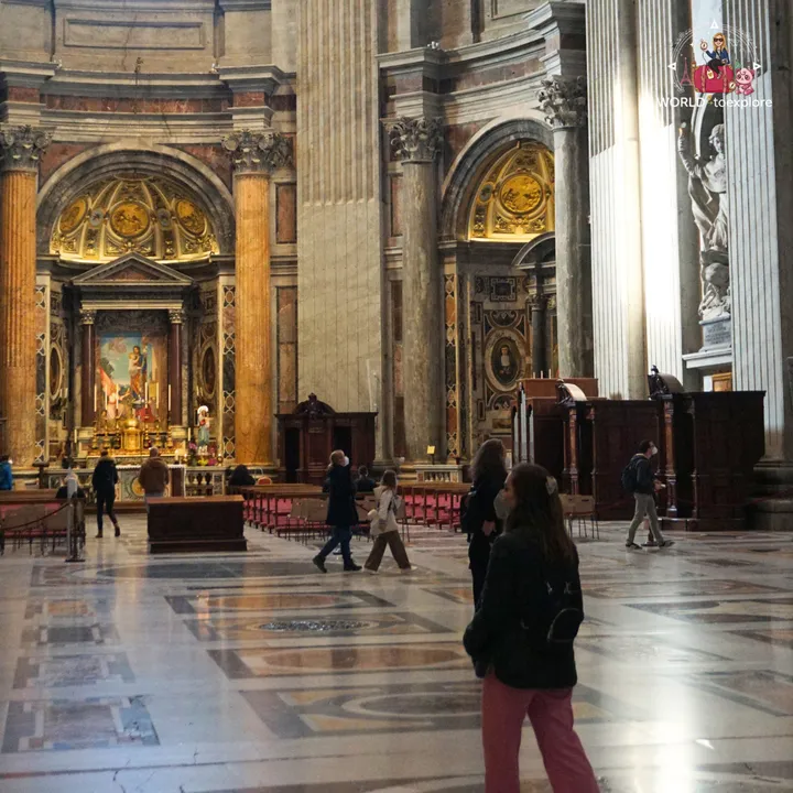 The author seen from behind in one of the side aisles of the basilica, with one of the altars and other visitors beyond
