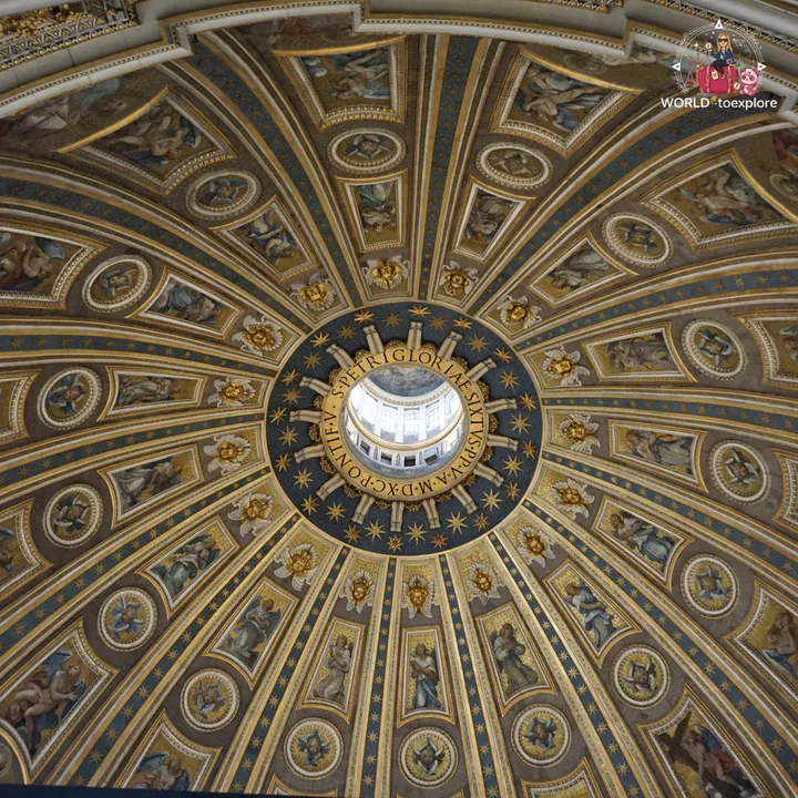 The inside of the dome of St Peter's Basilica seen from below, with the golden mosaics and the Latin inscription around the lantern