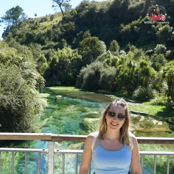 The author leaning on the railing of the Blue Spring viewing bridge, with the crystal-clear water and the forest behind