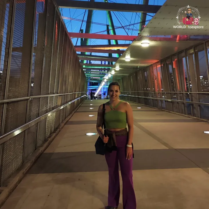 A pedestrian walkway lit up at night at South Bank, with colourful arches along the way