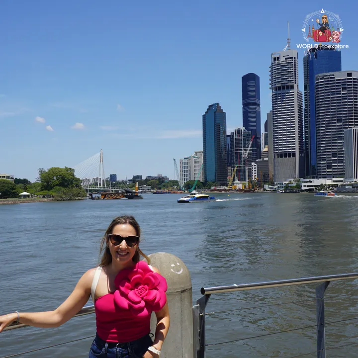 By the Brisbane River, with the city skyline and a CityCat ferry passing by