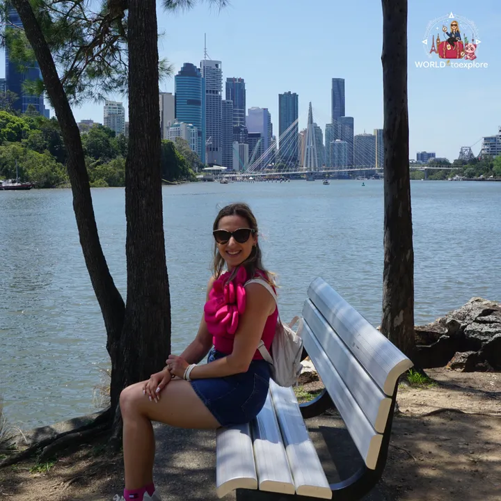 Sitting on a bench in the shade at Kangaroo Point, with the Brisbane skyline across the river