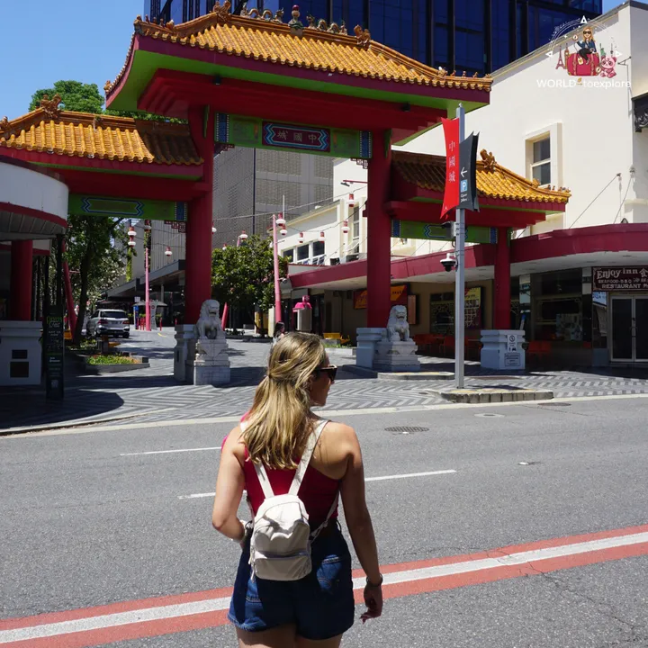 Crossing the street towards the Chinatown gate, with the stone lions and the red and gold arch