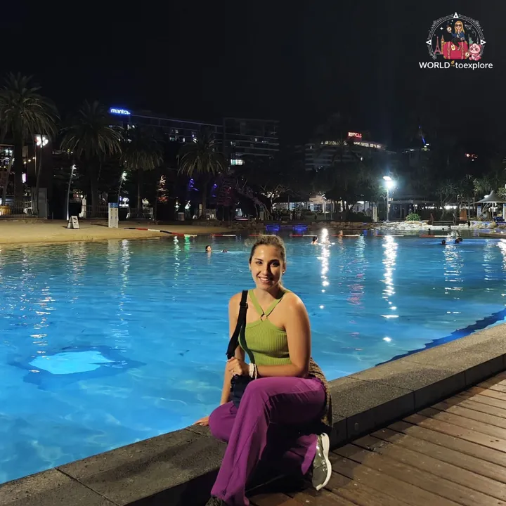 Streets Beach lit up at night, with the blue lagoon and the South Bank buildings in the background