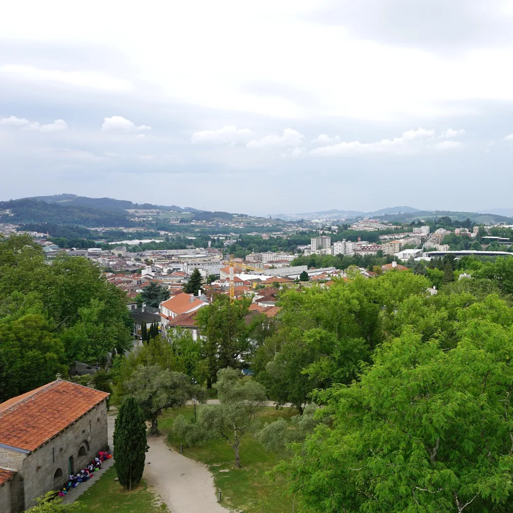 An elevated view over the rooftops of Guimarães and the hills beyond, seen from the top of the castle walls