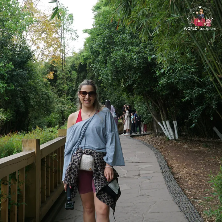 Cristina walking along a path surrounded by bamboo groves inside the park