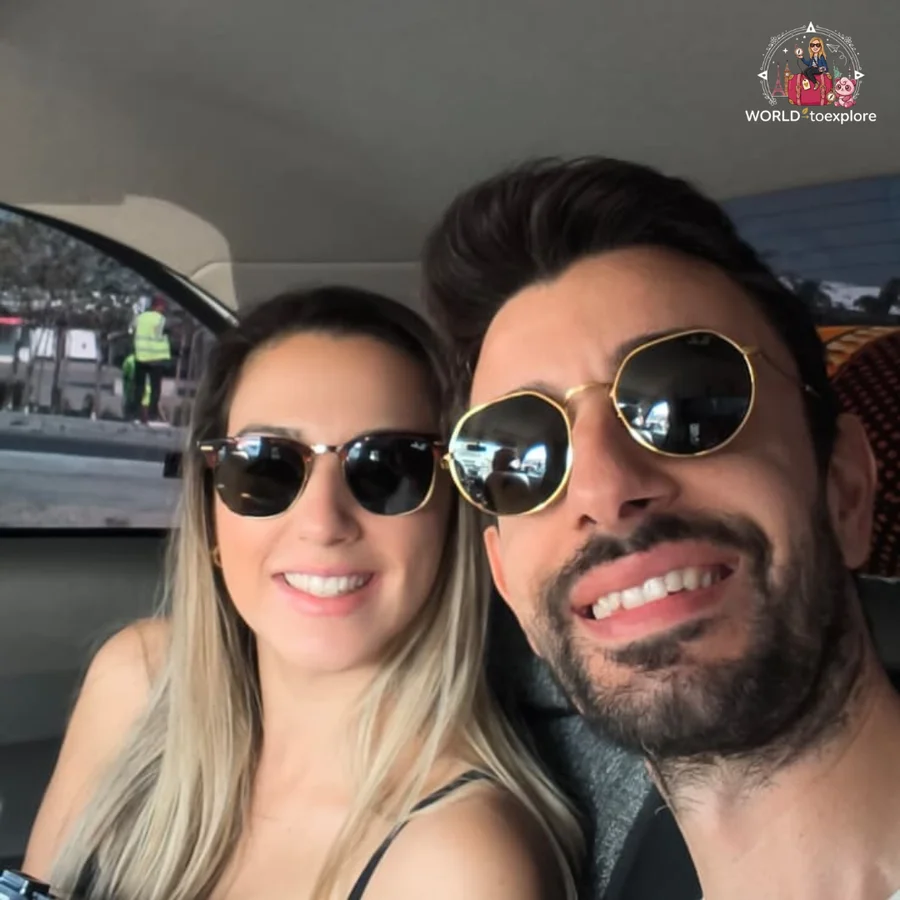 Smiling couple in sunglasses taking a selfie inside a car
