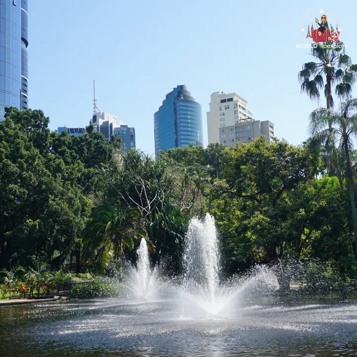 Fountain spraying in the lake of the City Botanic Gardens, with the Brisbane skyline behind
