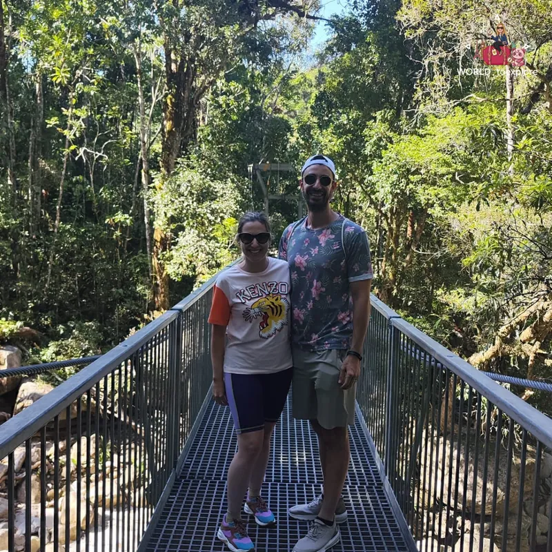 On the suspension bridge over the Mossman Gorge river, surrounded by rainforest