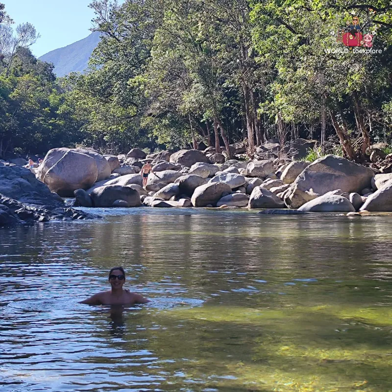 Swimming in the Mossman Gorge river, with the large boulders and the mountain behind