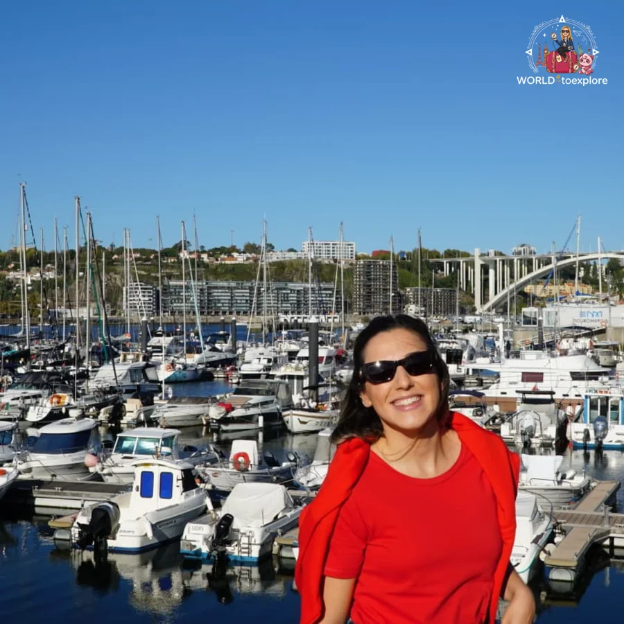 Cristina in sunglasses and a red top in the foreground, with Douro Marina full of boats and the Arrábida Bridge in the background