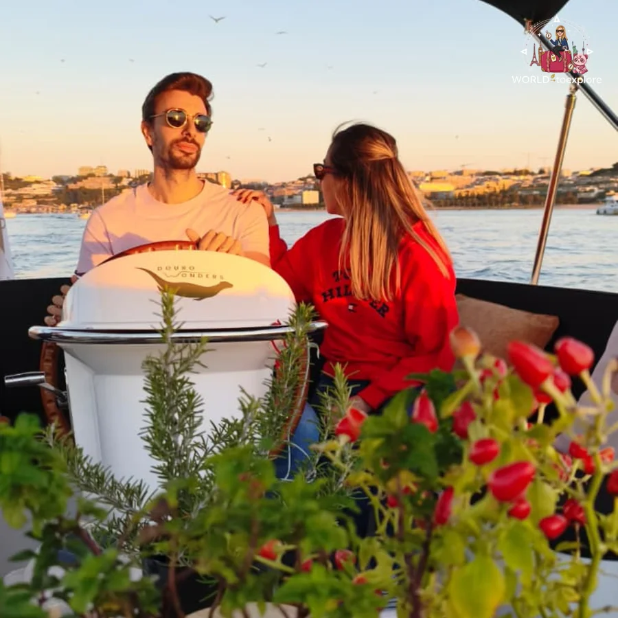 Her husband at the helm of the Wondy and Cristina sitting beside him, among plants with red berries, with the city coastline behind them
