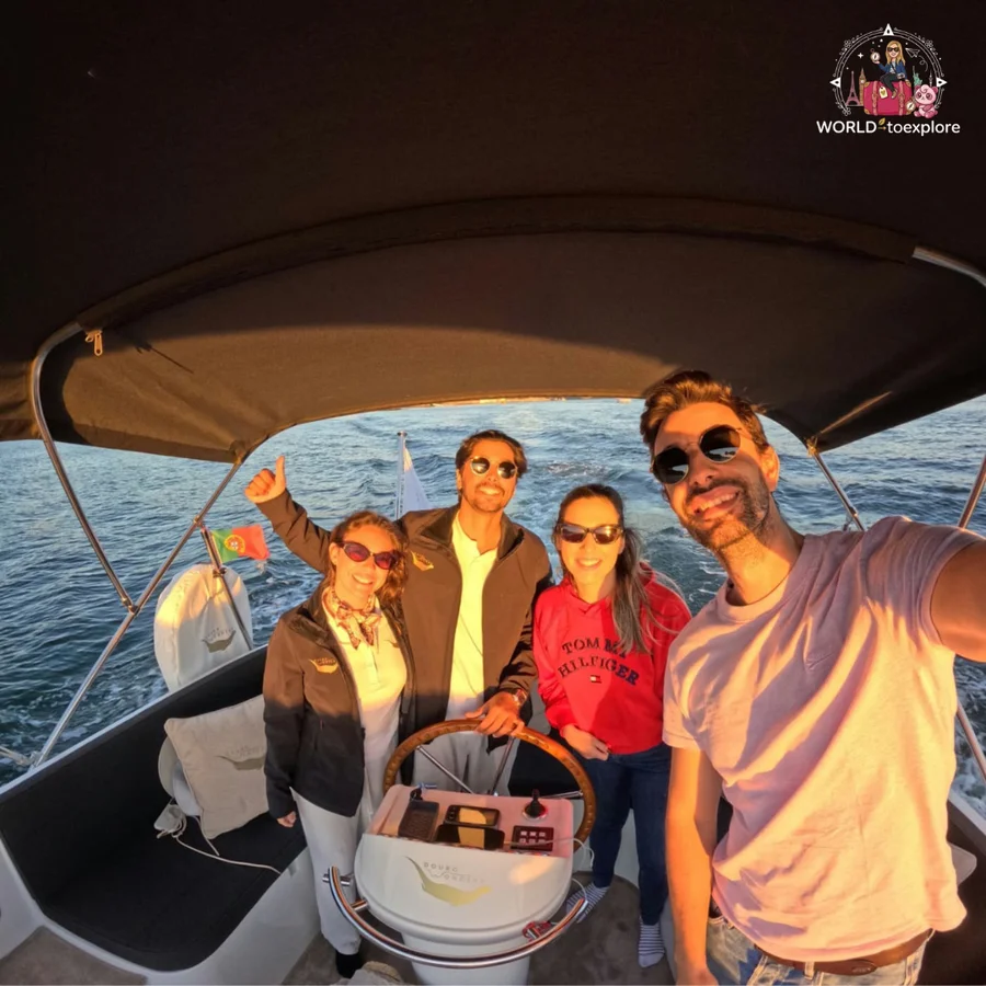 A group selfie aboard the Wondy, with Inês, António, Cristina and her husband smiling by the helm, the Portuguese flag and the sea behind them