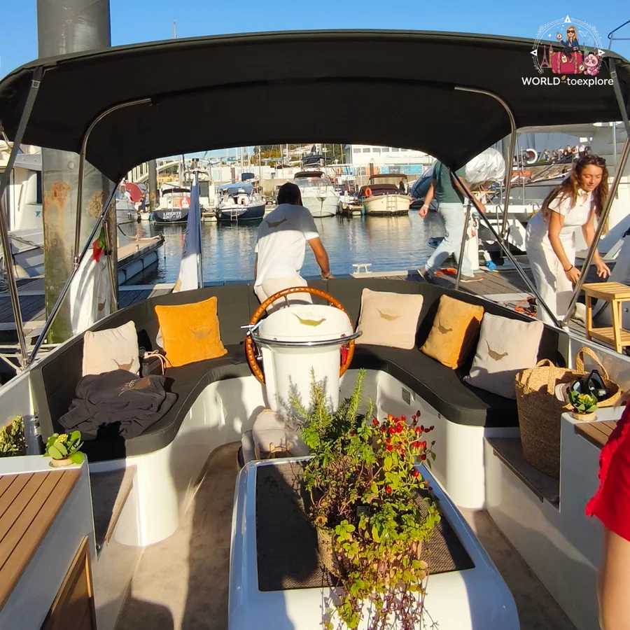 Inside the Wondy seen from the stern, with bench seating, mustard-coloured cushions and the crew preparing to depart