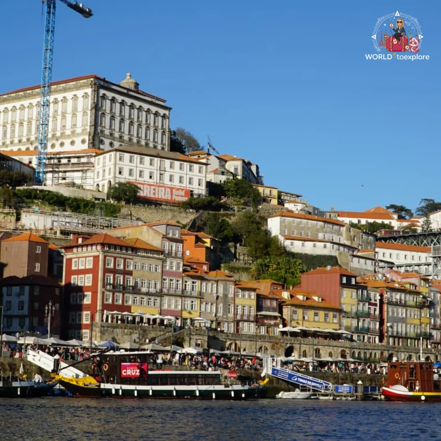 The Ribeira in Porto seen from the River Douro, with the Episcopal Palace at the top of the hill and colourful houses beside the water