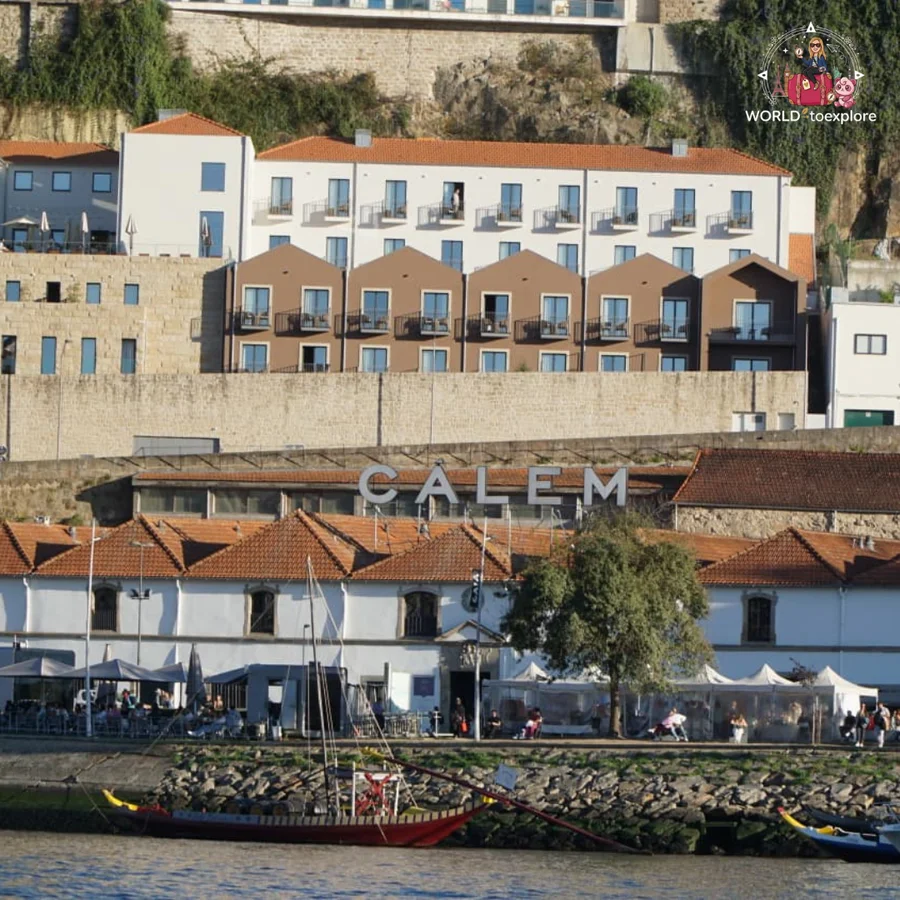 The Calém port wine cellars, in Vila Nova de Gaia, seen from the River Douro, with a rabelo boat on the bank