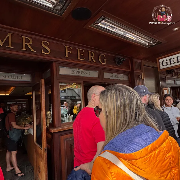 A queue of people at the door of Mrs Ferg, the ice cream shop next to Fergburger, with dark wooden signs for sorbet, espresso and affogato