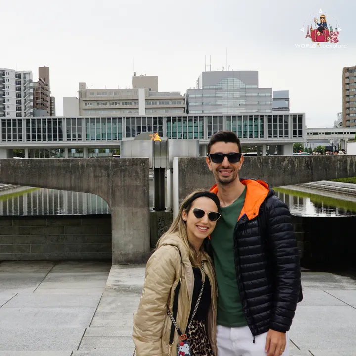 The two of us in front of the Peace Flame, with the park's pond on either side and the Hiroshima Peace Memorial Museum behind