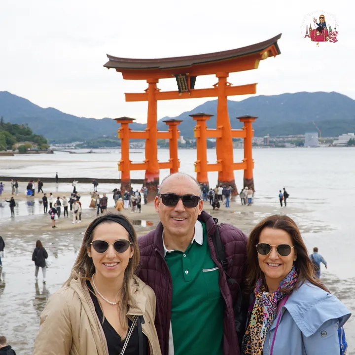 As a group in front of the great torii, with the tide out and visitors walking on the sand