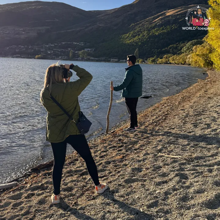 The author photographing her partner by the water at Frankton Beach, during their late-afternoon walk