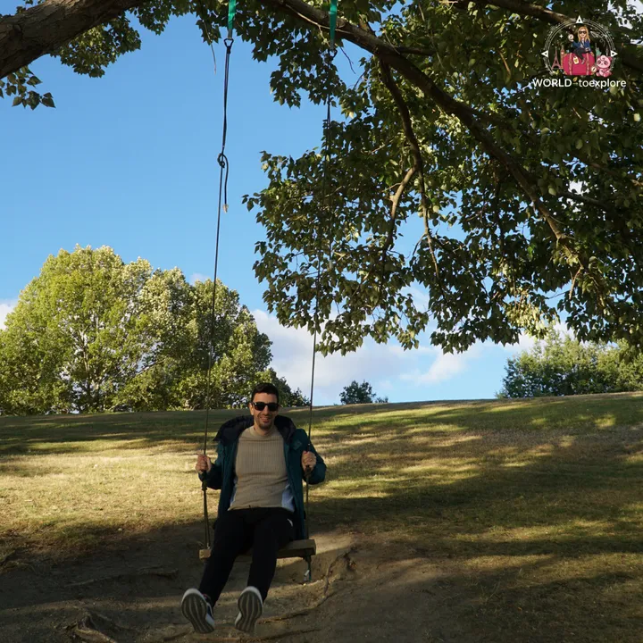 A man sitting on a swing under a tree, in the Peace Park Wakatipu Reforestation Trust