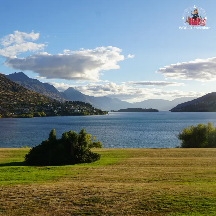 Grassy area by the shore of Lake Wakatipu, with the Queenstown mountains in the background