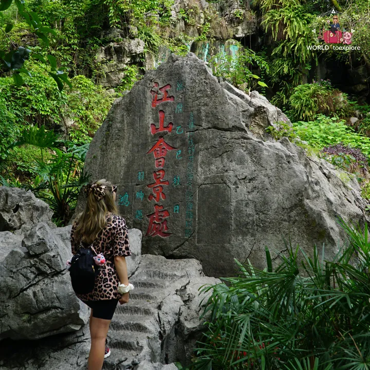 Cristina looking at a rock with an old inscription carved in Chinese characters
