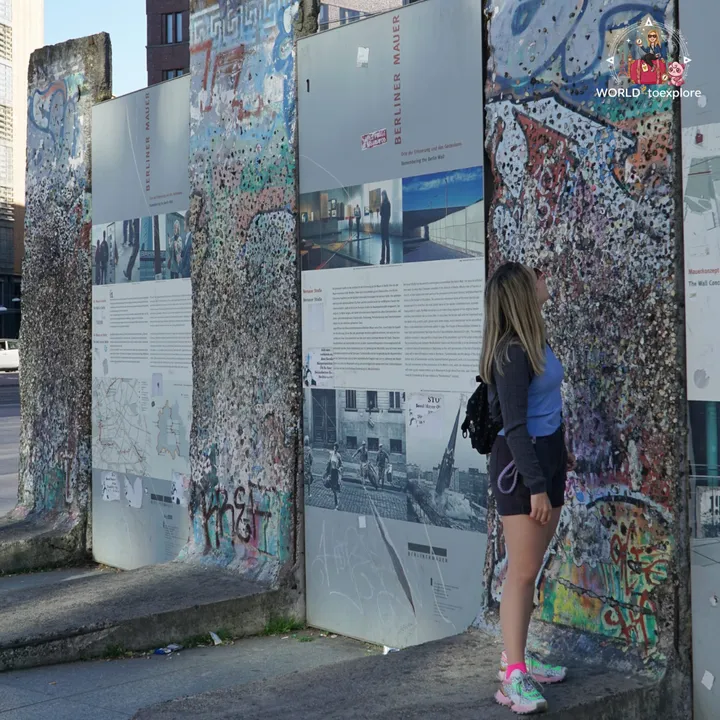 Looking at stretches of the wall standing on the street, next to information panels telling the history of the Berliner Mauer