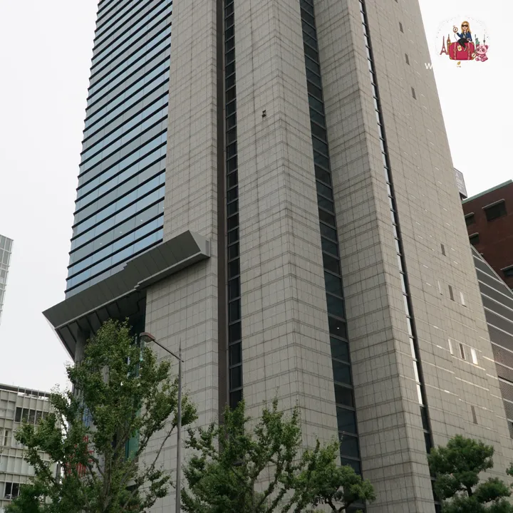 View looking up at the Phoenix Tower façade in Nakanoshima, with trees in the foreground