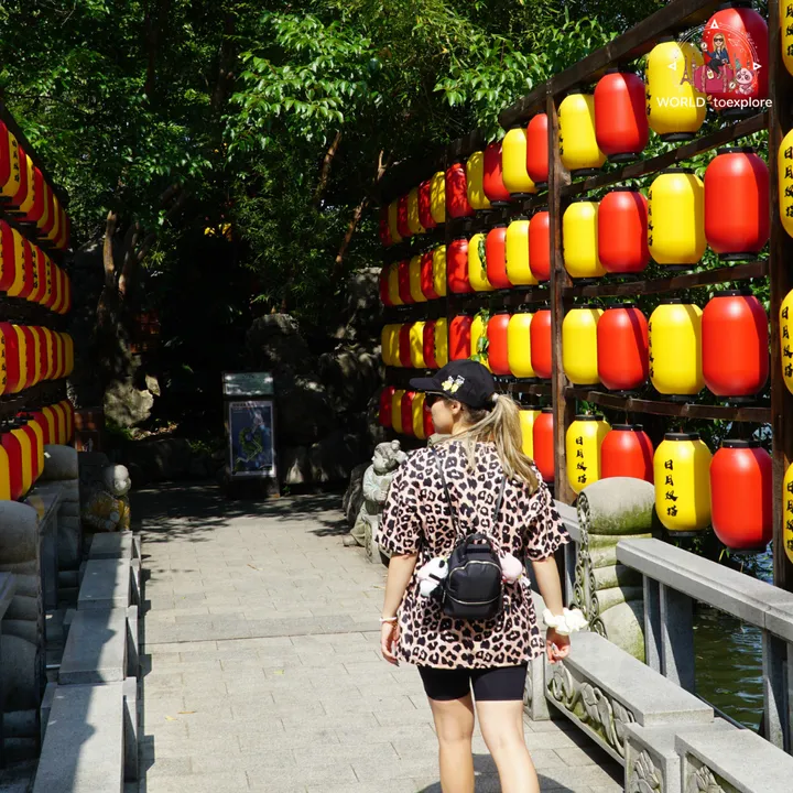 Cristina walking through a corridor decorated with red and yellow lanterns