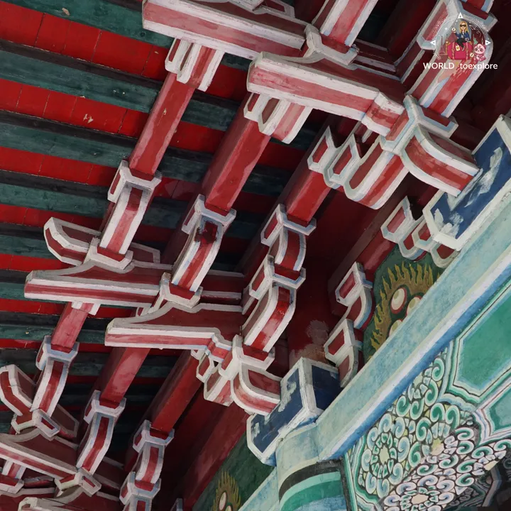 Close-up of the painted wooden eaves of one of the pagodas, with traditional Chinese motifs