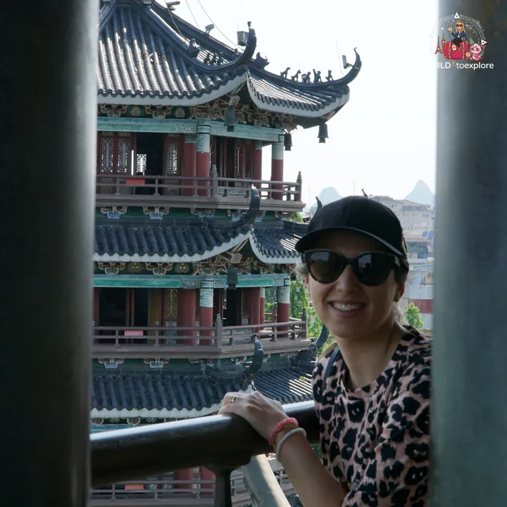 Cristina smiling next to a metal railing, with the Moon Pagoda in the background
