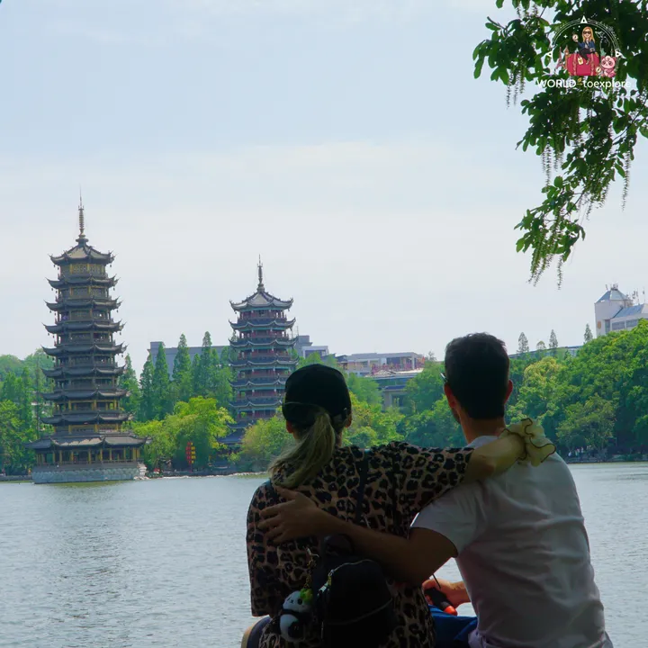 Couple embracing, looking at the two pagodas from a boat, during the day