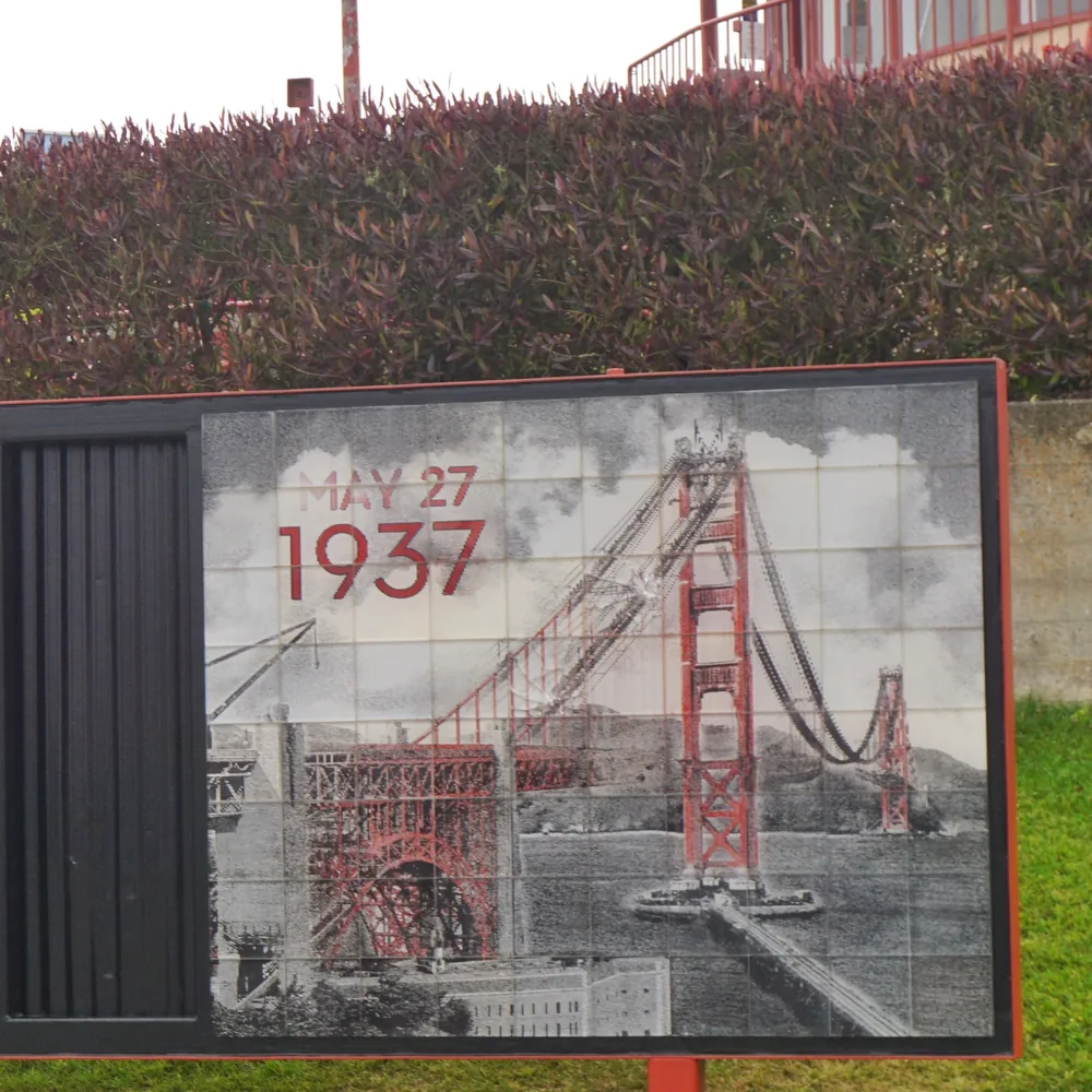 A tiled panel with a historic photo of the Golden Gate Bridge under construction and the date May 27, 1937