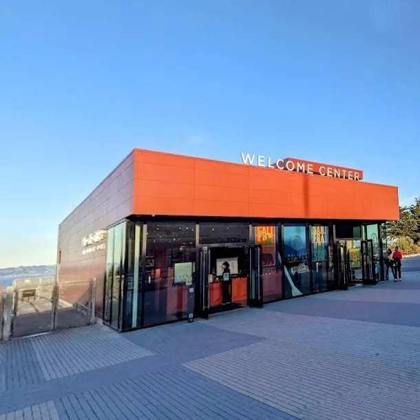 The orange facade of the Golden Gate Bridge Welcome Center, with its glass entrance and Welcome Center sign