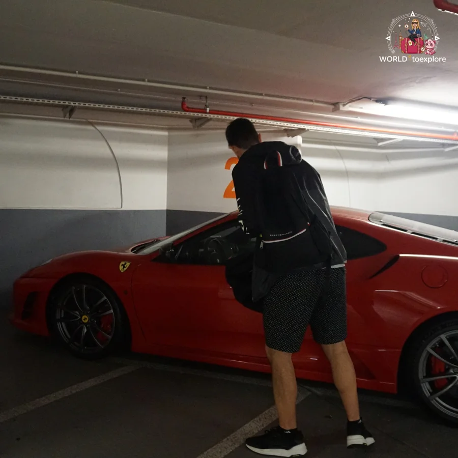 Man peering into a red Ferrari in an underground car park