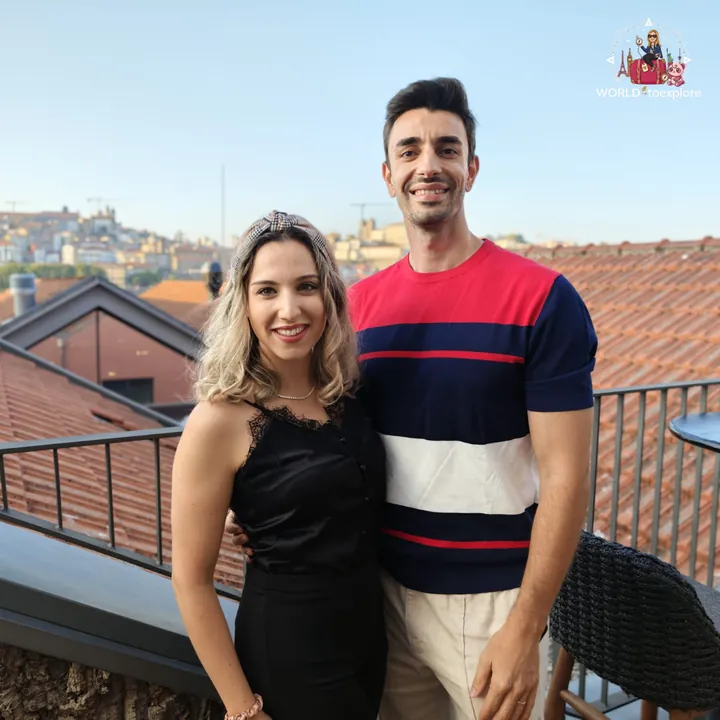 Cristina and her husband on the RENATA terrace, with the tiled rooftops and old town of Porto behind, on a sunny day