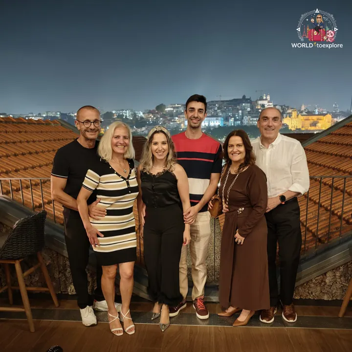 The group of six on the RENATA terrace at night, with the city of Porto lit up across the Douro