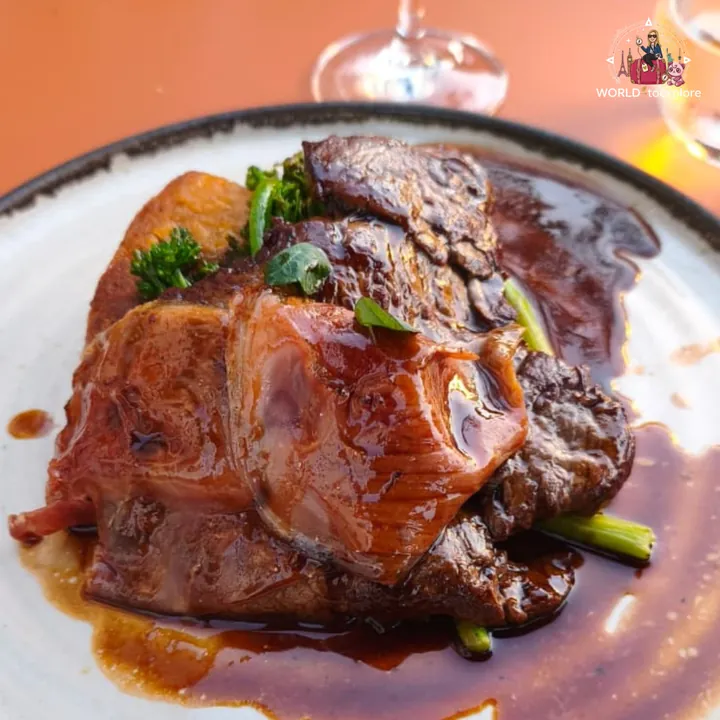 The Bife de Lombo 'Autóctone' Nacional à Portuguesa, coated in a dark, glossy sauce, with broccoli and potato, served on the terrace