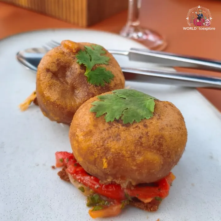 The Nordic cod fritters, golden, topped with coriander and set over roasted peppers