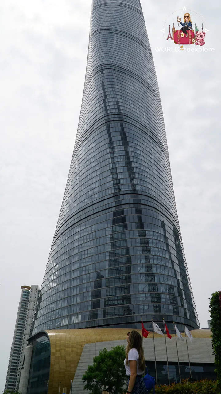 The Shanghai Tower's spiralling glass façade seen from the base, near the entrance