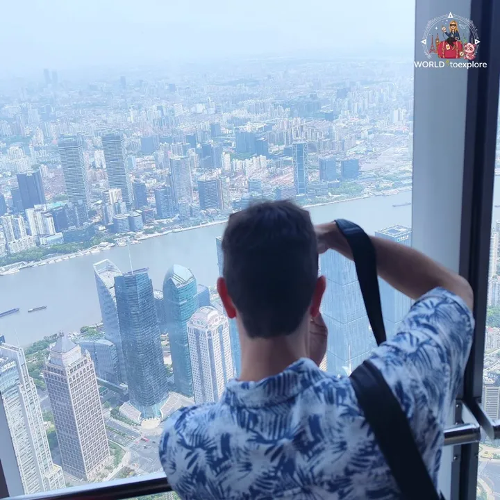 Photographing the view over the Huangpu River and the city from the 118th-floor observatory