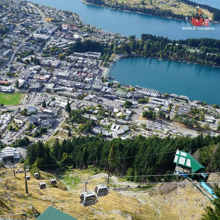 Aerial view of downtown Queenstown and Lake Wakatipu, with Skyline Gondola cabins descending the hillside