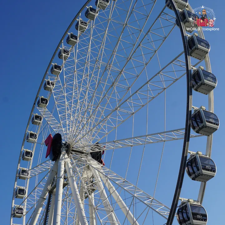 Close-up of the Wheel of Brisbane against the blue sky, with the suspended cabins