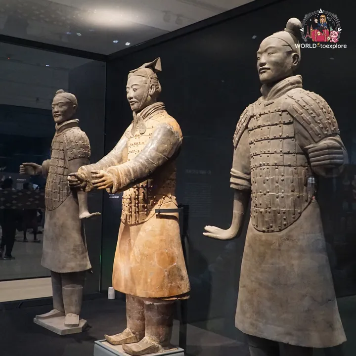 Three terracotta warriors, including an officer, on display in a museum case